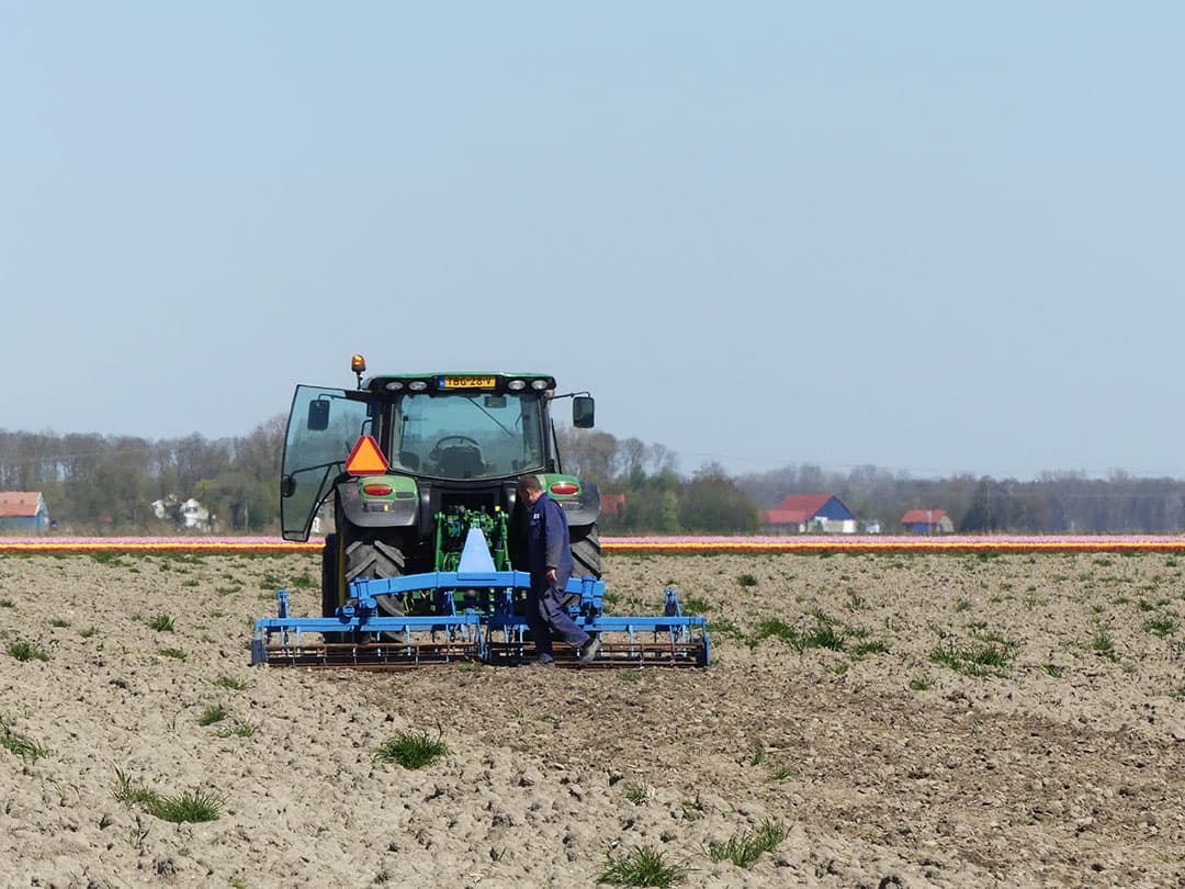 André Adamse maakt aan de Ellerweg in Biddinghuizen (Fl.) de eerste werkgang op een perceel waar bieten komen. Het is een voorbewerking. Koppen vlakken en het kleine onkruid bestrijden. Het land ligt vrij grof geploegd, maar is daardoor bovenop ook voldoende uitgedroogd en wil ook wel verkruimelen. Door de zachte winter en het late voorjaar beginnen plukken gras de kop op te steken. Op het perceel komen ook nog proefvelden waardoor het zaaien nog niet meteen in één klap klaar zal zijn. - Foto: Martin Smits