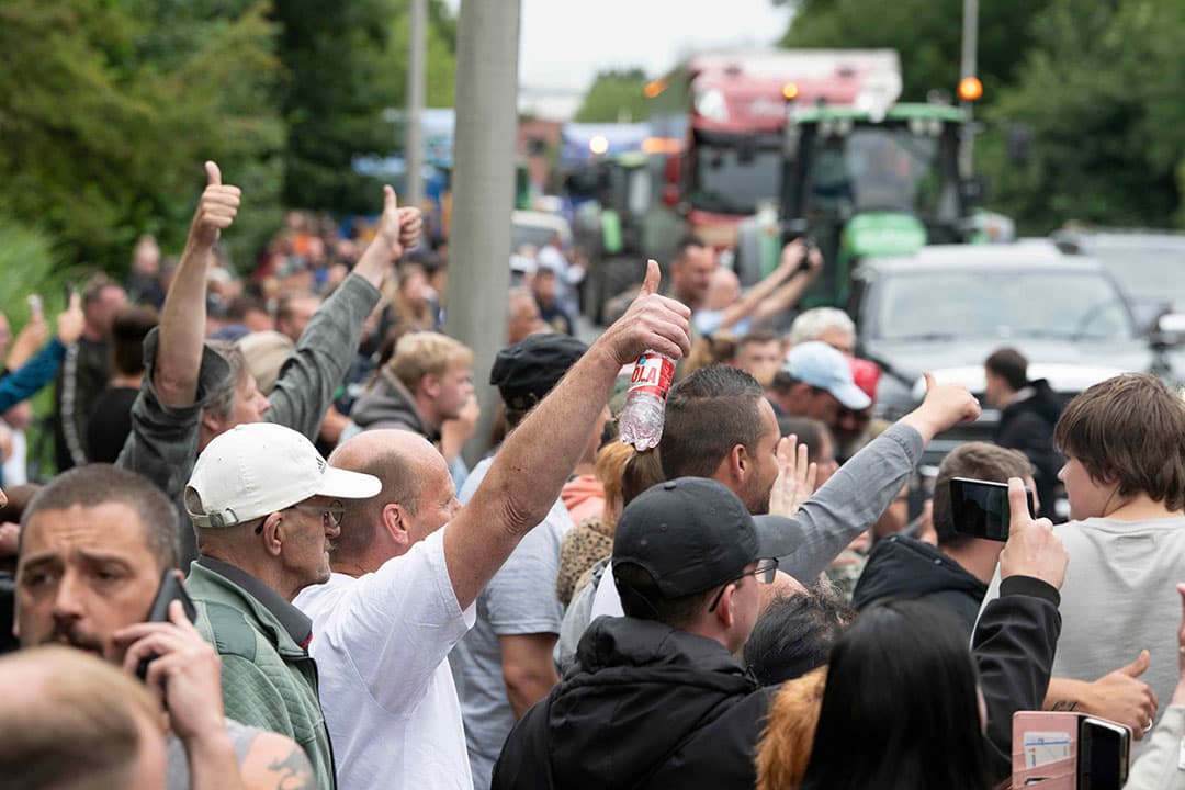 Toeschouwers van een boerenprotest in Leeuwarden uiten hun steun. De boerenorganisaties zijn nu eensgezind om het gesprek met Johan Remkes aan te gaan. - Foto: Mark Pasveer
