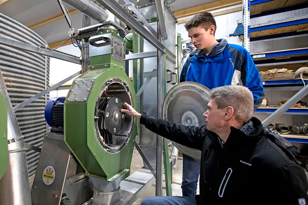 Veneman controleert samen met een van zijn zonen de hamermolen die zorgt voor een optimale maalfijnheid van het rantsoen.