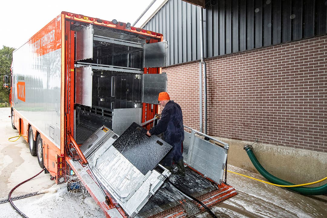 Een chauffeur van Varkenshandel Dijk reinigt en ontsmet een vrachtwagen na het afleveren van biggen op een varkensbedrijf in Ambt Delden (Overijssel). - Foto's: Ronald Hissink