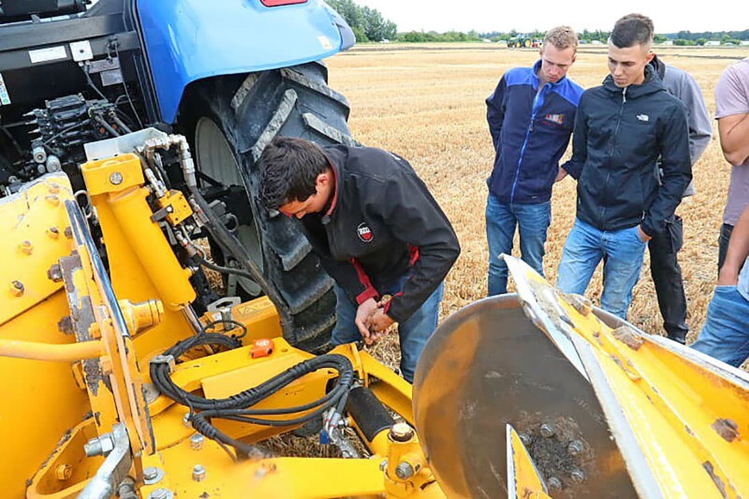 Een van de belangrijkste punten bij ploegafstelling is instellen van de treklijn. Hier corrigeert instructeur Kees de Rijke de treklijn aan de ploeg van Jan en Koen Lampert, die ook het perceel gerststoppel beschikbaar hebben gesteld. De correctie is als donker stukje schroefdraad zichtbaar aan het eind van de treklijnstang.