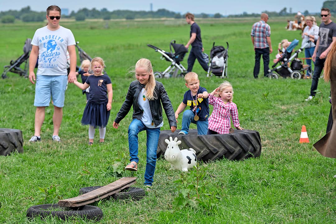De kinderen vermaken zich bij de kalfjes in het strohok in de schuur. Dochter Barbera Moerman heeft naambordjes gemaakt, die boven het hok hangen.