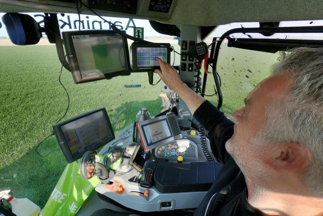 De bestuurder van de sleepslangtrekker - Bert Nap van Aarnink & Ooms - bedient de aanvoer vanuit de trekker op het veld. Het kastje dat hij nu bedient, is van de container waar hij kleppen open of dicht kan zetten. Hiermee wordt het toerental van de containermotor automatisch aangepast aan de toevoer van de meststroom door de sleepslang.