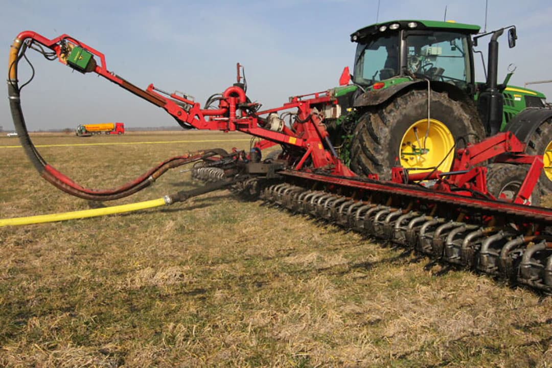 De mest wordt met een sleepslangsysteem over de graszaadstoppel gereden.