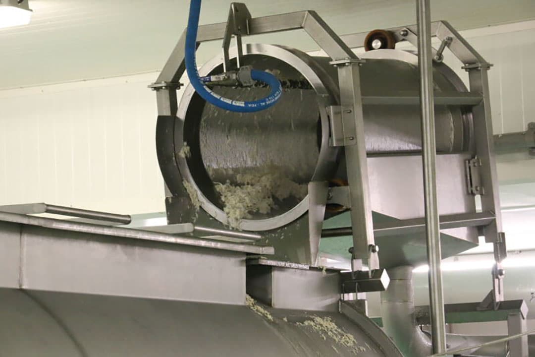 Met tussenpozen wordt het gedroogde product uit de droger op de opvoerband gedeponeerd.