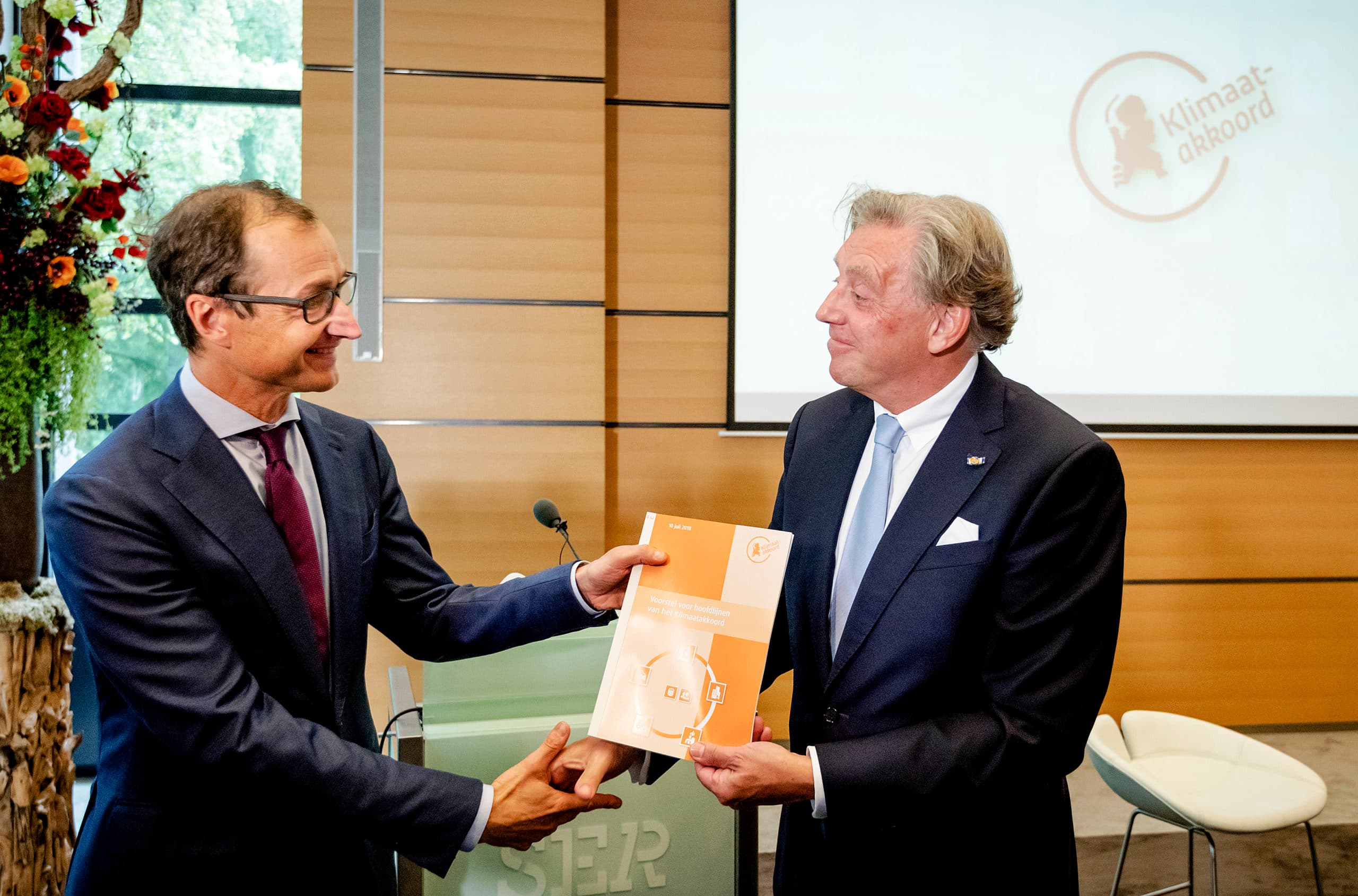 Minister Eric Wiebes (links) neemt het klimaatakkoord in ontvangst van Ed Nijpels. - Foto: ANP