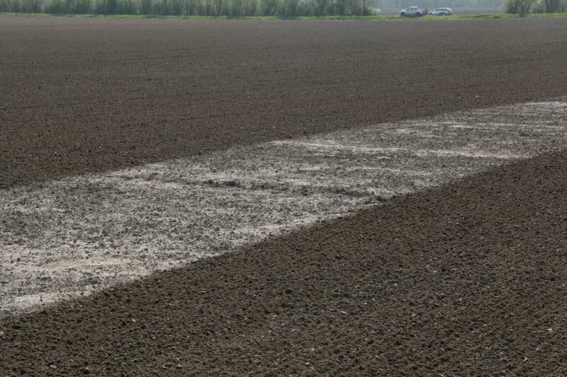 Terwijl de bieten worden gezaaid, legt Den Hartog een ander perceel klaar voor het zaaien van uien. Dat de bovengrond droog is, laten de trekker banden goed zien.