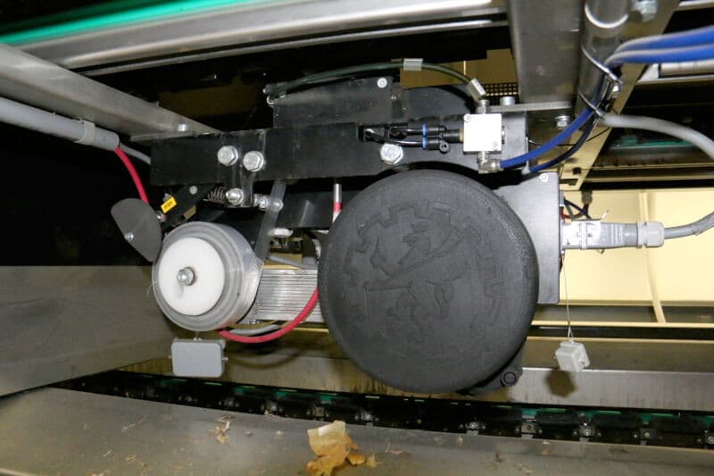 De uien komen vanaf de opvoerband in twee V-vormige transportbanden om de uien op een lijn te krijgen. Vanaf deze banden komen de uien op de cups van de detectiebanden. Op de achtergrond de retourband die doorloopt tot aan het eind van de machine. Op deze band komen de uien die dubbel liggen of niet gedetecteerd konden worden; deze krijgen een herkansing.