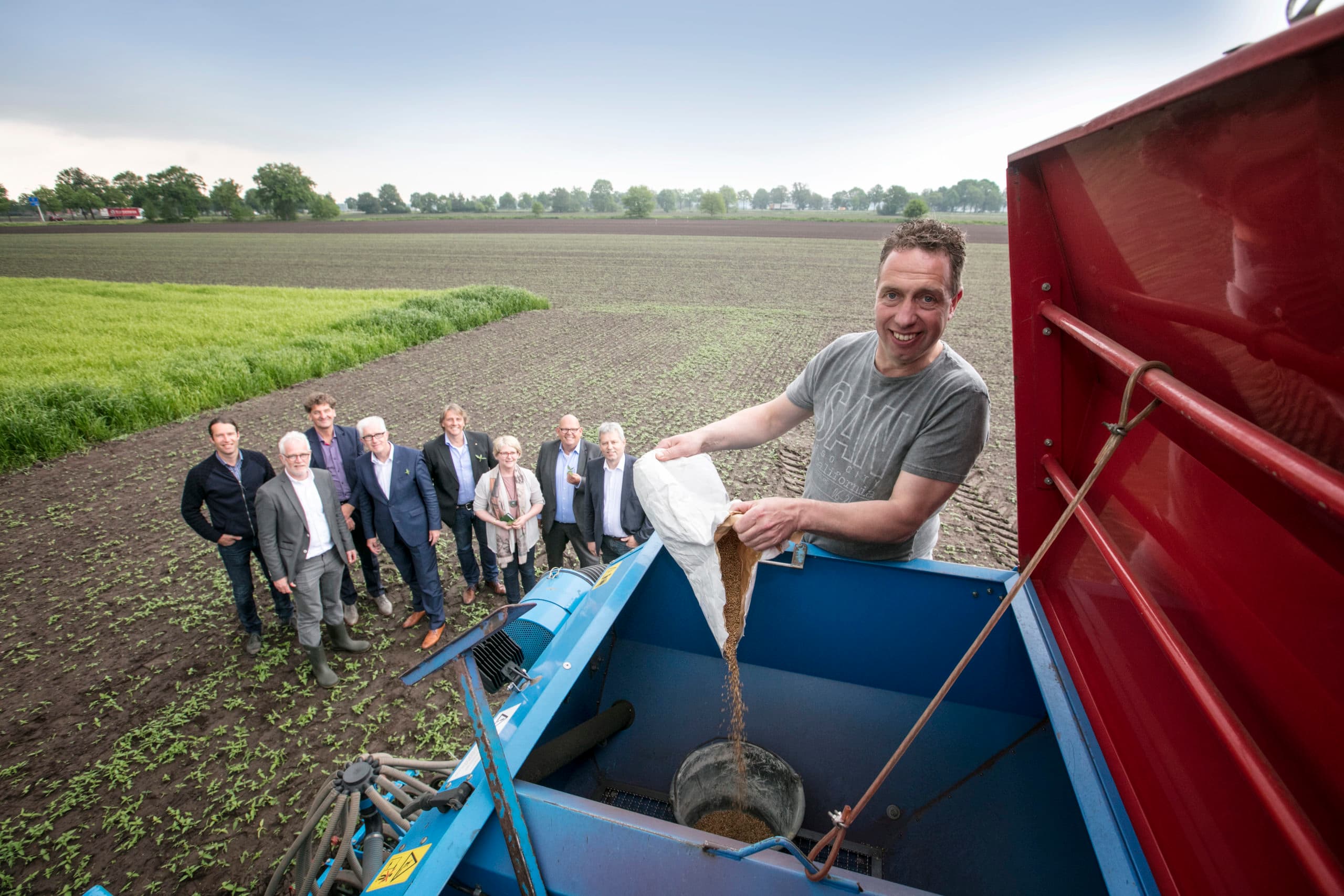 Bij het in gebruik nemen van de proeflocatie in Agro As de Peel, afgelopen voorjaar, strooit melkveehouder Geert Hol symbolisch sorghum zaad in de zaaimachine. - Foto: Sandra Peerenboom