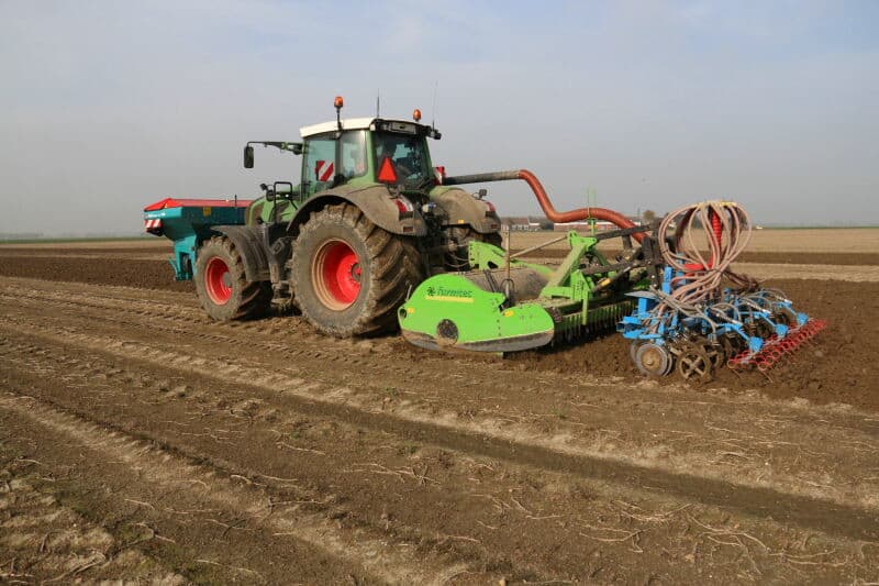 Bij maatschap Buth in Dirksland (Zuid-Holland) zaait een medewerker wintertarwe op een aardappelperceel. Op de achtergrond is Buth nog witlof aan het rooien. - Foto's: Anton Dingemanse
