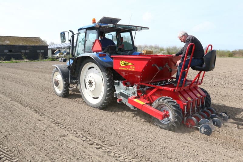 De voorkant van de machine met de luchtcompressor die voor de pneumatiek zorgt. Bovenaan beide zijden zitten de plantschijven voor verschillende maten plantgoed.