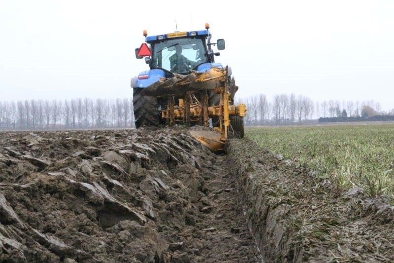 Het is hier de bedoeling dat de bemester de pompunit achteruit van de afrit duwt, en dan met de unit aangekoppeld naar het volgende perceel gaat. Deze afrit is vorig jaar gerenoveerd en de opgebrachte grond is nog los, zodat de pompunit tijdens deze manoeuvre ongewenst ging schuiven. Om schade aan boom, berm en unit te voorkomen, werd besloten om met behulp van een tweede trekker en een fikse ketting de unit op de weg te krijgen. De pompunit kwam nu zonder probleem op de weg.