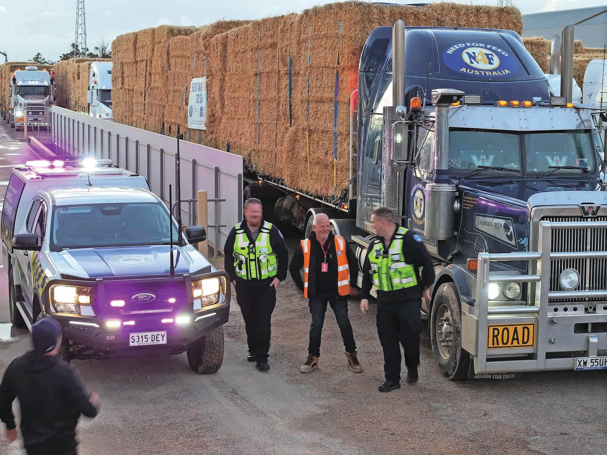 Voorman Graham Cockerell van Need for Feed Australia in gesprek met de politie tijdens het transport van het hooi voor door droogte getroffen veehouders. De politie begeleidde de lange rij vrachtwagens. Foto: Need for Feed Australia