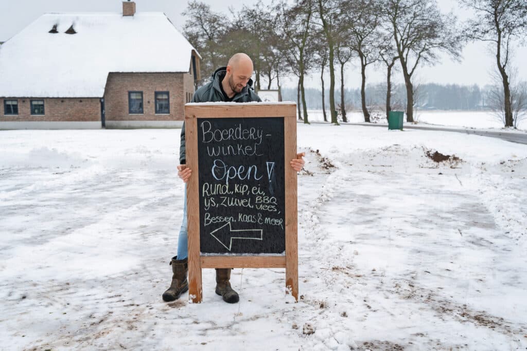 Erik zet het bord voor de winkel klaar. Hij zou ook wel een boerencamping willen, maar dat is momenteel te veel. ‘Je moet niet alles willen.’