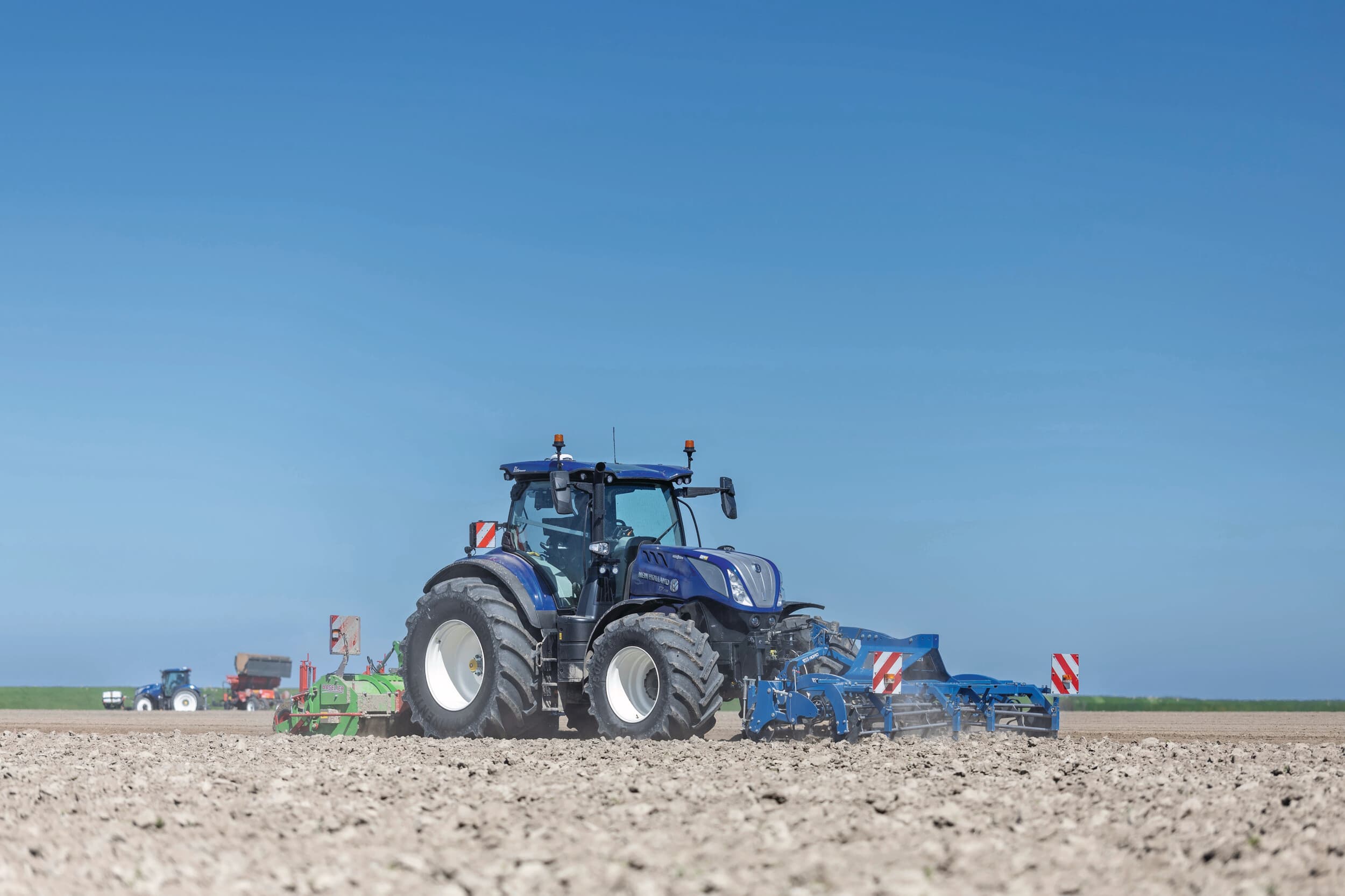Medewerkers van maatschap Noordam ten Have poten op 21 april consumptieaardappelen in Usquert (Gr.). Na ploegen met een John Deere-trekker wordt met New Holland-trekkers de grond verder bewerkt, waarna direct gepoot kan worden. Op dit perceel van 15 hectare gaan Arizona’s de grond in. Foto: Mark Pasveer