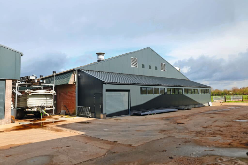 Rechts de stal waarin ruimte is gemaakt voor de varkens. In de kipper die tegen de stal staat valt de vaste mest die onder de varkens vandaan komt. Foto's: Bert Jansen