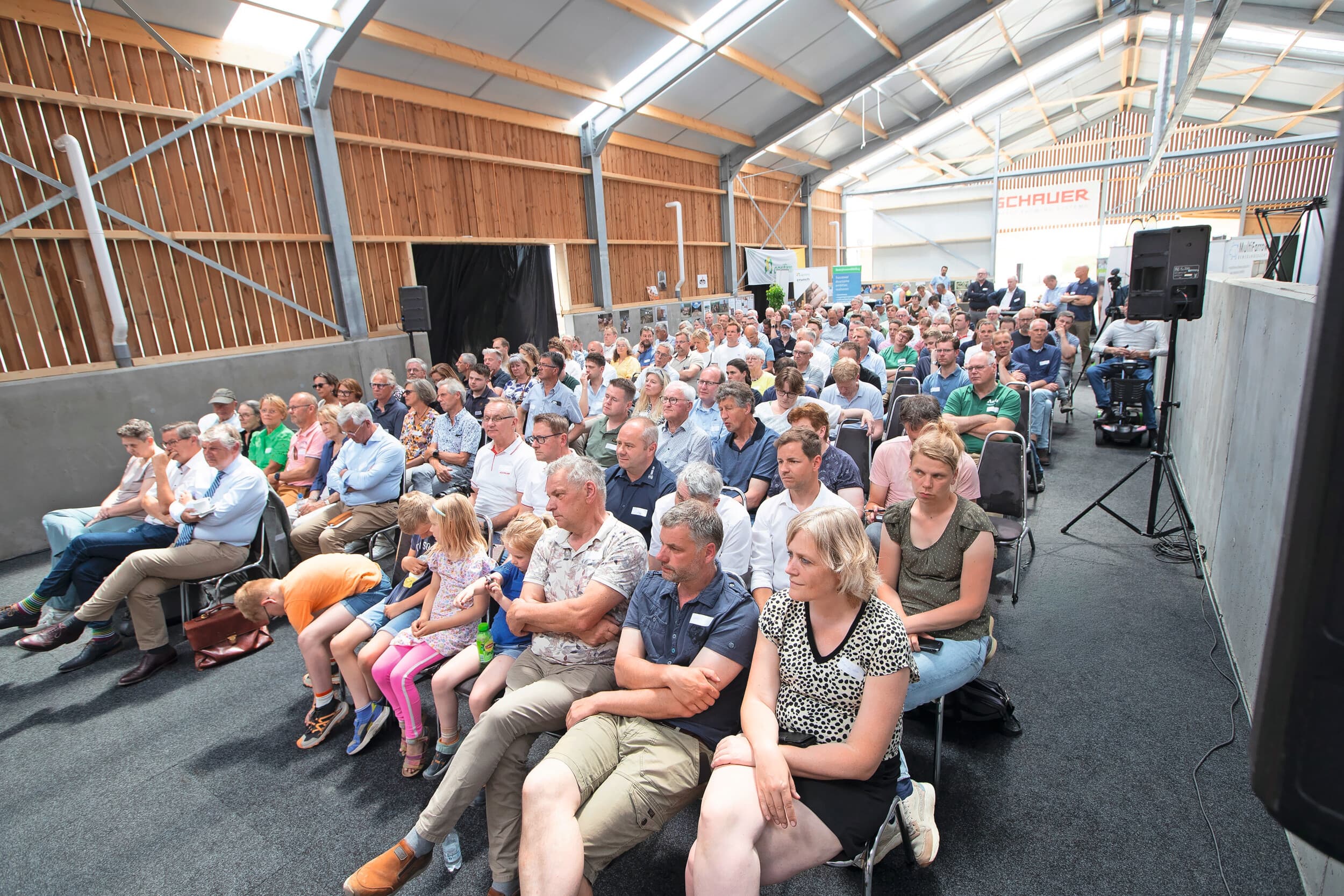 Tijdens het symposium wordt ingegaan op de keuze voor de houten stalbouw en de toekomst van biologische productie en het verdienmodel. De toehoorders luisteren aandachtig. Foto: Hans Banus.