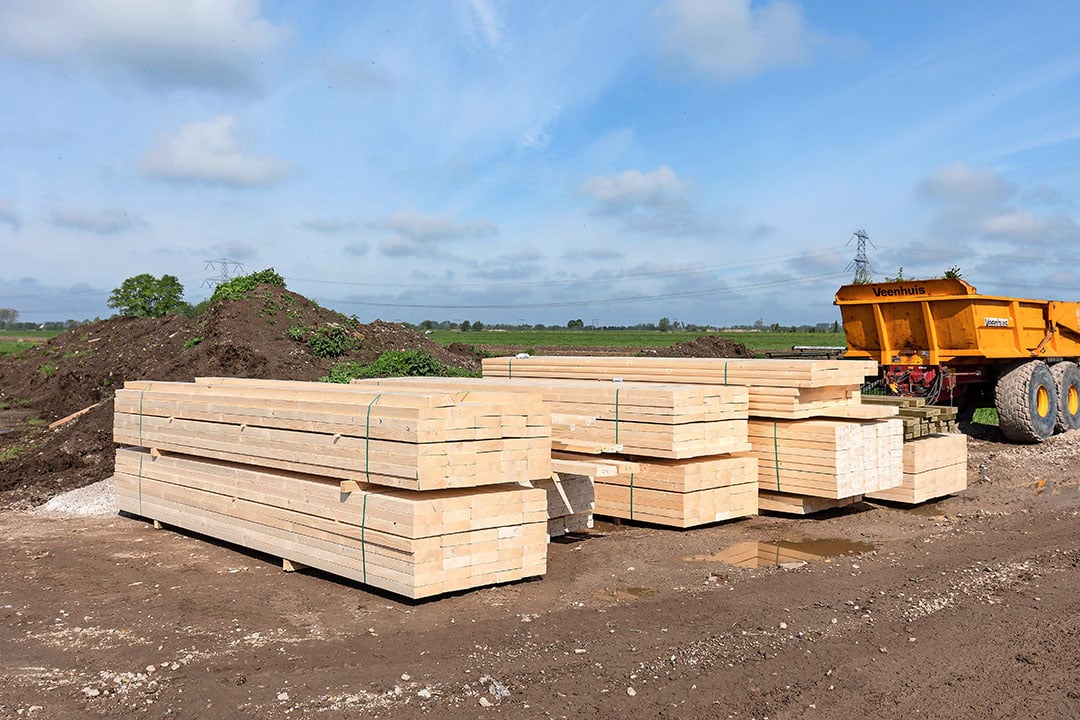 Stapels hout liggen klaar voor de bouw van de nieuwe geitenstal van familie Olsthoorn. Volgens Huisman Gemert zijn vurenhouten balken zeker 100% in prijs gestegen sinds de start van dit jaar.