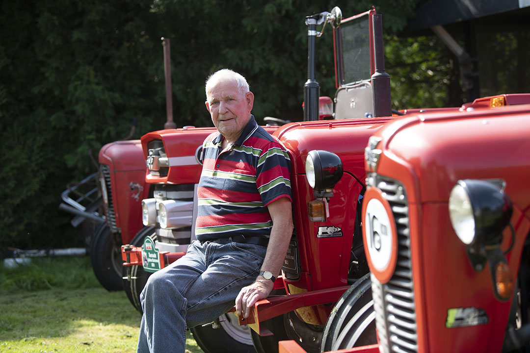 Trots poseert Jan Wassenaar bij zijn verzameling oldtimers.