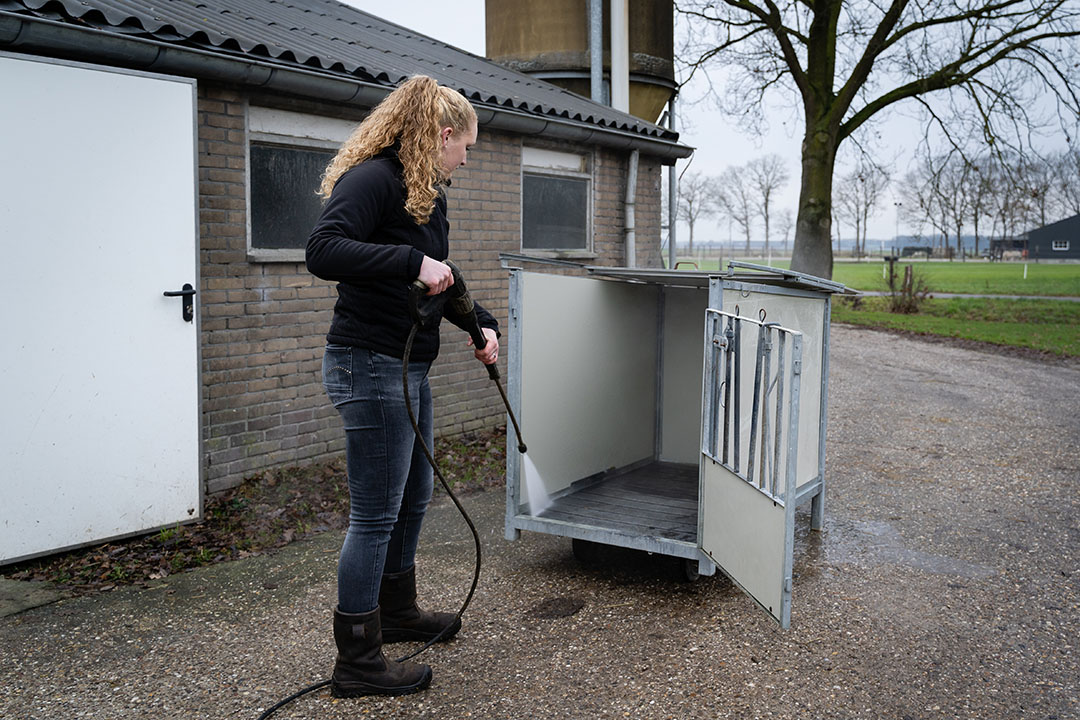 Schoonspuiten van een kalverbox. Janine heeft eigenlijk nergens een hekel aan op de boerderij.