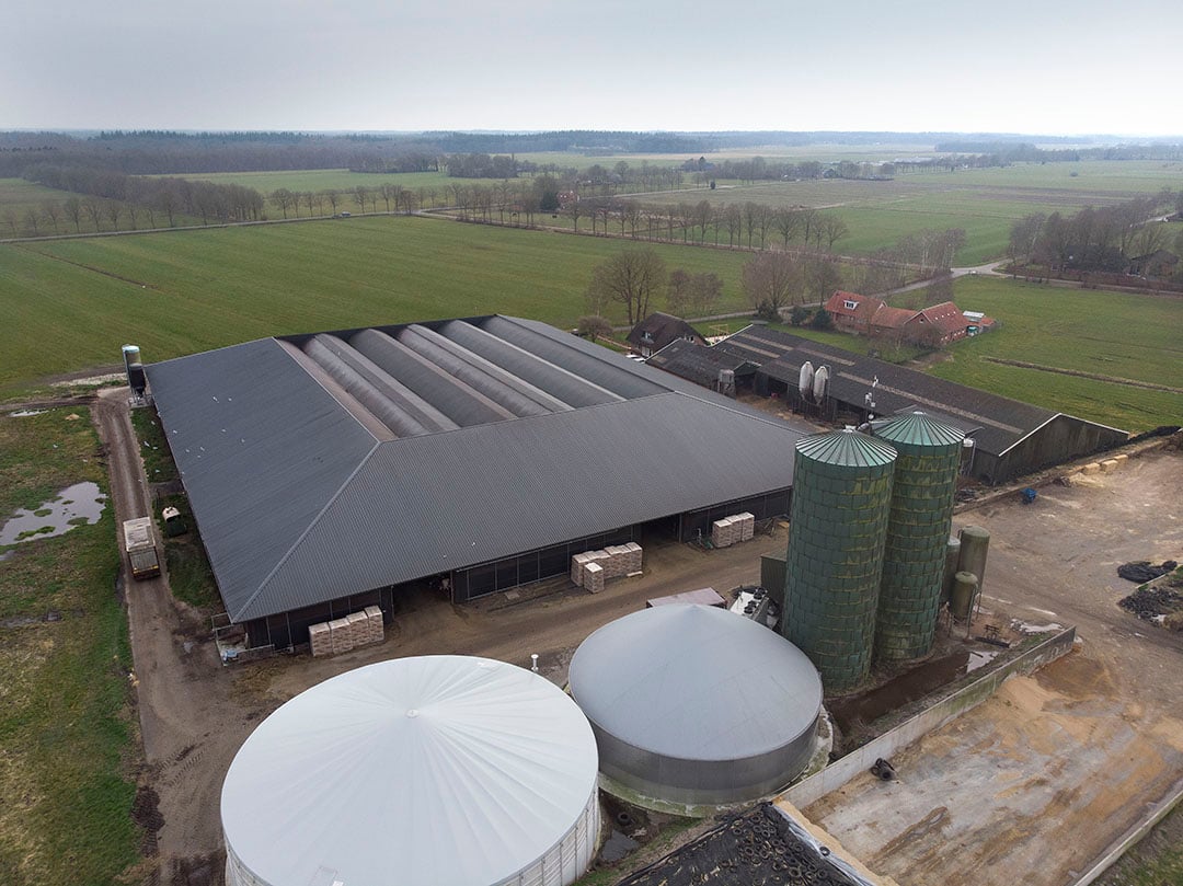 Het bedrijf vanuit de lucht gezien met onderin de mestvergister.