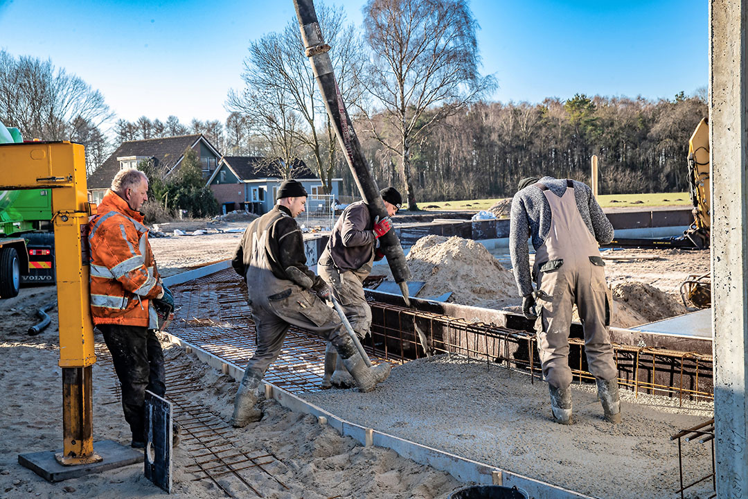 Het storten van beton voor de voergang van een bijzondere nieuwe melkveestal in aanbouw - een roundhouse.