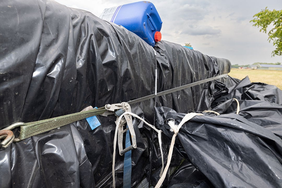 Een spanband voorkomt dat het gewicht van het water de gestapelde foliebalen uit elkaar drukt. Check regelmatig of de spanbanden nog goed vastzitten.