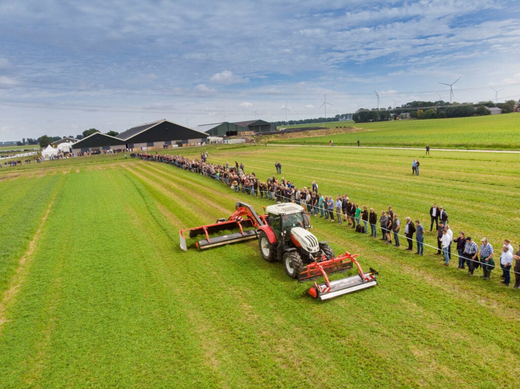 Kuhn kan nu ook een front gemonteerde bandhark leveren die de gewasstroom in gelijke delen naar links en rechts kan splitsen. De trekker rijdt dan niet meer over het gras en de fronthark met een bandhark achterop ontstaat toch een egale wiers.