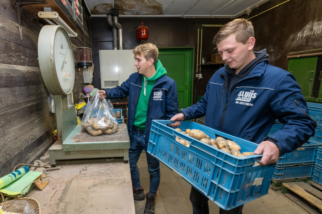 Mart (groene trui) en Bram willen de handel in aardappelen graag uitbreiden. Bij kleine afnemers in de omgeving is er vraag naar en de marge is groter dan wanneer alles weg gaat voor de bulk.