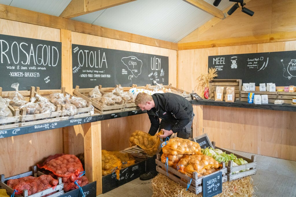 In de boerderwijwinkel die op het erf staat, liggen onder andere aardappelen en uien van eigen bedrijf.
